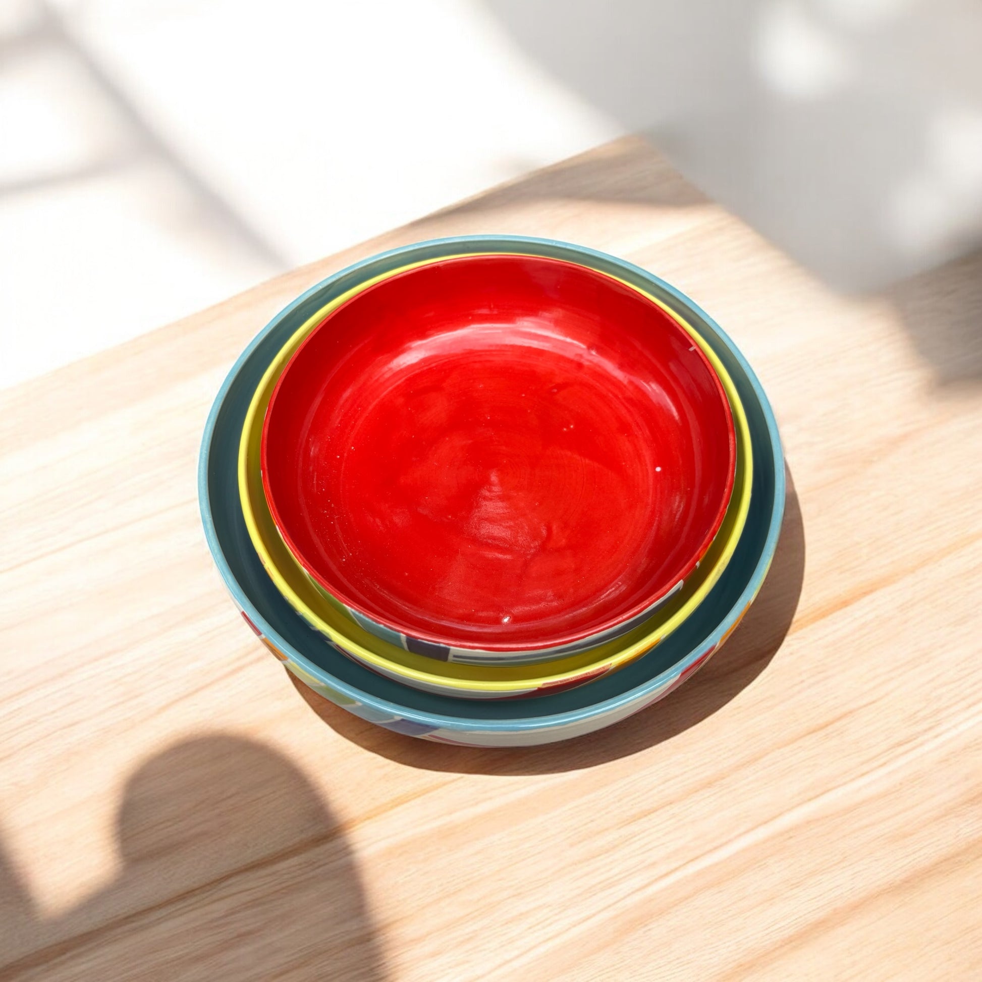 Stack of colorful ceramic bowls on a wooden surface